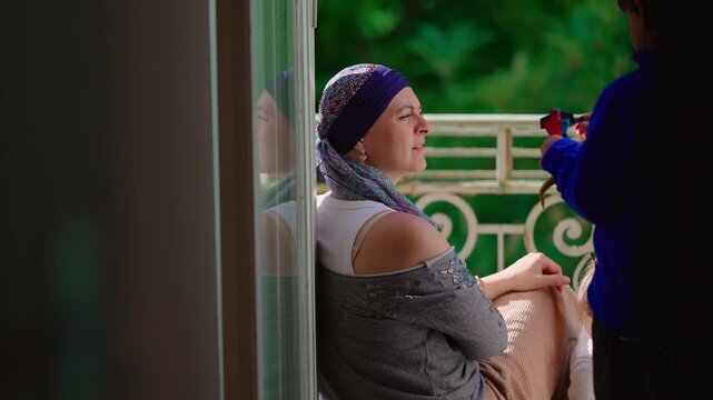 Woman undergoing chemotherapy spending time with child on balcony, candid family moment highlighting resilience, connection, emotional support and meaningful relationships during recovery