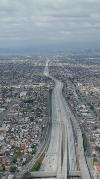 AERIAL: Spectacular View over Endless City Los Angeles, California with Big Highway Connecting to Downtown on Cloudy Overcast Day 