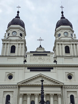 Symmetrical neoclassical facade and twin dome bell towers of the Metropolitan Cathedral (Catedrala Mitropolitană) in Iași, Romania, under an overcast sky.