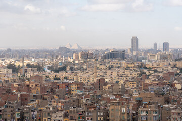 Fototapeta premium Telephoto view of Giza Pyramids and Cairo city skyline