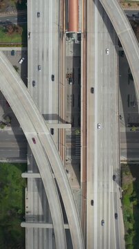 AERIAL: Spectacular Overhead follow Shot of Judge Pregerson Interchange showing multiple Roads, Bridges, Highway with little car traffic in Los Angeles, California on Beautiful Sunny Day