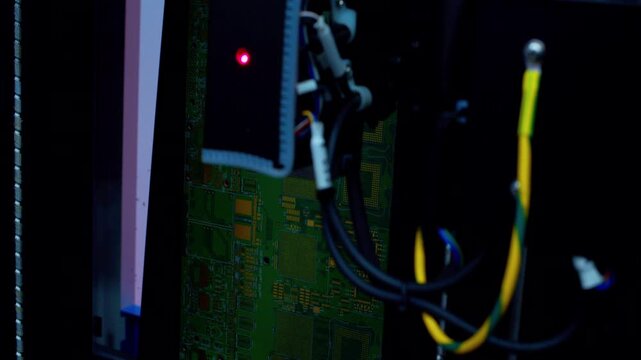 Close-up of modern industrial machinery manufacturing electronic circuit boards. A specialized high-precision robotic arm conducts automated testing to verify the assembly accuracy of PCB components.