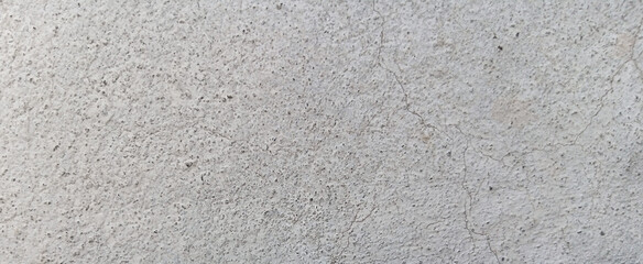 Fototapeta premium Gritty concrete texture background, weathered light gray cement wall surface, industrial stone floor with grainy detail and subtle cracks