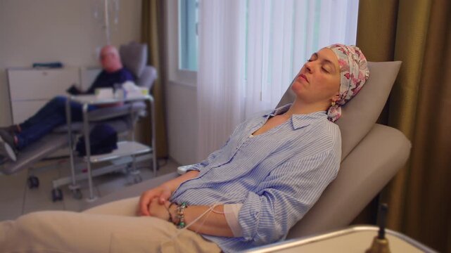 Female cancer patient resting during chemotherapy session in healthcare clinic, medical treatment environment highlighting recovery, endurance and patient wellbeing