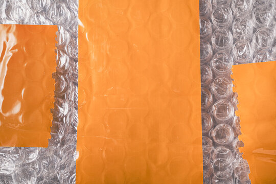 Orange tape and bubble wrap mailer plastic packaging for safe delivery filling frame