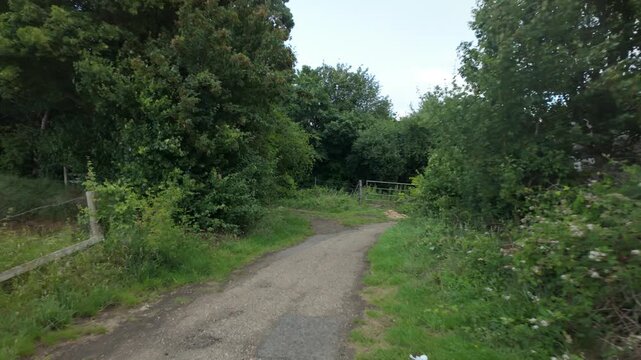 Alwalton and Castor Circular, Cambridgeshire, UK - 09 June 2026: Walking point of view, gimbal stabilised sequence, around a corner on a public footpath, under a bridge, then into a woodland trail.