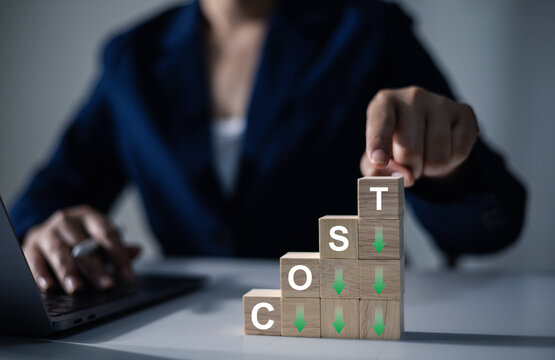 A businessman's hand with a wooden cube: business development concepts, cost reduction concepts, optimizing production management, reducing company expenses to maximize profits.