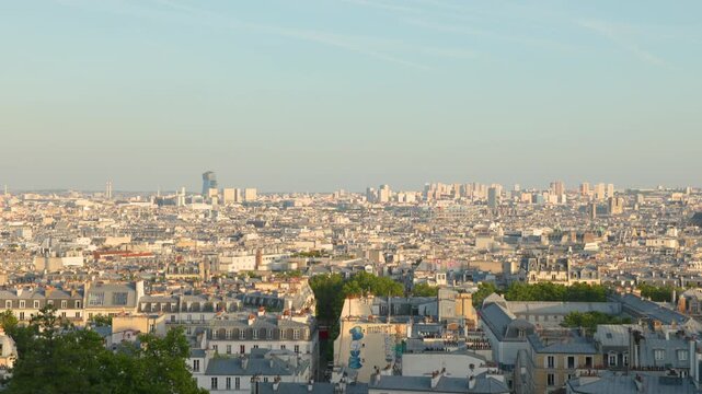 A wide static panoramic view over the sprawling cityscape of Paris, showcasing endless traditional rooftops and urban architecture under a clear, bright sky.