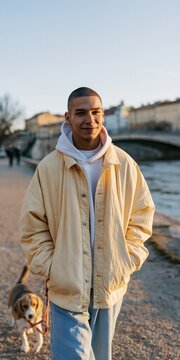 Young man walking a dog by the river at sunset for lifestyle background and urban banner design