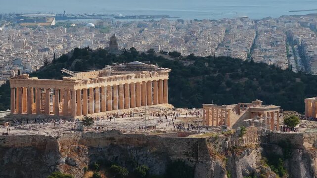 People visiting ancient Parthenon temple at Acropolis of Athens, Greece, cityscape revealing historical landmark and archeological site, doric columns and ruins