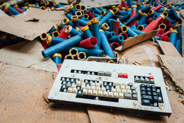 Vieux clavier et vieilles bobines de fil dans des cartons éventrés dans une usine abandonnée. Faillite industrie textile Lorraine et Vosges © david