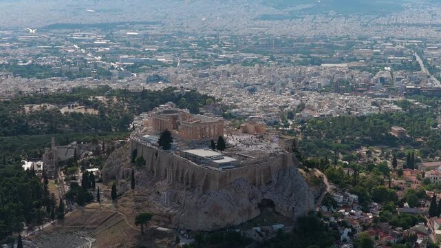 Scenic elevated orbiting panorama of ancient Acropolis of Athens, Parthenon temple, Odeon of Herodes Atticus, revealing historic landmarks of Greece's capital