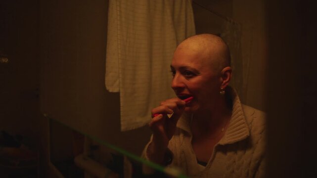 Woman brushing teeth during cancer recovery in home bathroom, highlighting personal care, resilience, wellness, hygiene and everyday self care routine