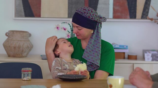 Mother embracing toddler during family mealtime at home, highlighting attachment, emotional connection, nurturing care, comfort and loving family relationships