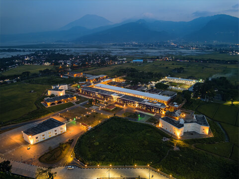 Aerial view of the historic Benteng Fort Willem I illuminated at night, surrounded by lush rice fields and distant mountains in Ambarawa, Central Java, Indonesia.