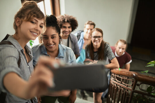 Diverse college students taking selfie on staircase