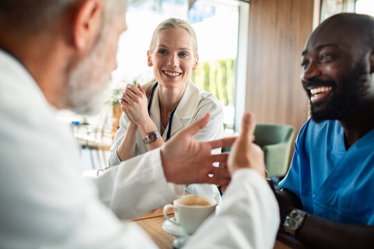 Healthcare colleagues discussing over coffee in hospital cafeteria