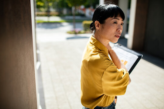 Professional woman with tablet at modern office courtyard