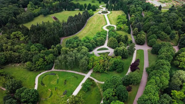 Green Urban Park Forest Drone View Aerial Recreation Landscape Infrastructure. This sweeping high-angle aerial photograph showcases a vast city park with intricately designed circular pathways