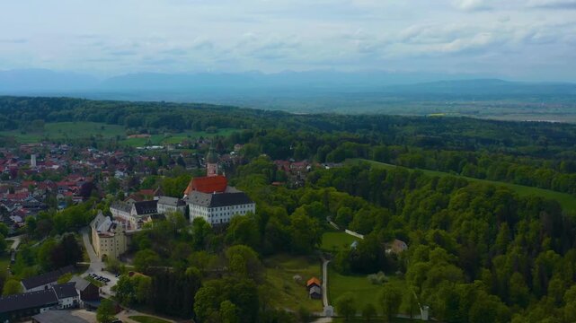Aerial view above the city and monastery Andechs beside the Ammersee lake, on a cloudy noon in Spring in Germany