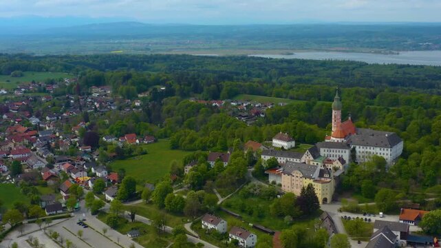 Aerial view above the city and monastery Andechs beside the Ammersee lake, on a cloudy noon in Spring in Germany
