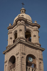 Fototapeta premium Tacna Cathedral presides over the main plaza in warm rose-tinted stone under an immaculate deep blue sky, its twin baroque bell towers and ornate neoclassical facade creating one of the most architect