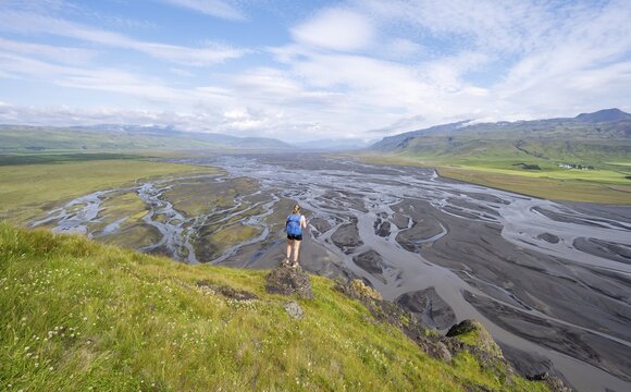 Hiker, Young woman on a hill, view over alluvial land, meandering river, D&iacute;monarhellir, Su&eth;urland, Iceland