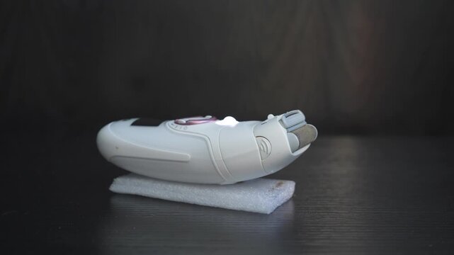 High-quality sound recording in uncompressed WAV format of a female epilator with a smooth shaving attachment, producing a clean buzzing motor sound from a home grooming device for audio library use.