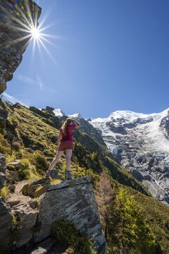 Hiker looking at glacier Glacier de Taconnaz, view from the hike La Jonction, Chamonix, Haute-Savoie, France