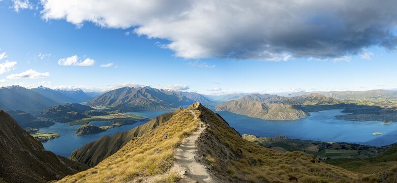 Hiker on a ridge, view of mountains and lake from Mount Roy, Roys Peak, Lake Wanaka, Southern Alps, Otago, South Island, New Zealand