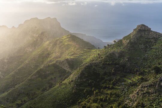 View of the Barranco Juan de Vera and its mountains, palm trees, rocks and sea. Near Mirador Degollada de Peraza. La Gomera, Canary Islands, Spain