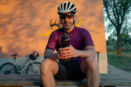 Cyclist resting, hydrating on gravel cycling break