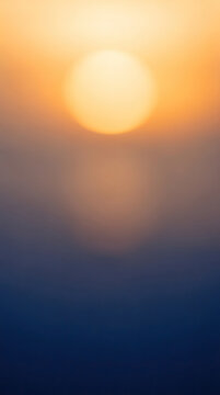 Abstract Blurred Sunset Sky with Bokeh Effect. Warm Orange and Blue Gradient Background with Sun