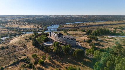 Naklejka premium Aerial drone view of ancient hilltop ruins above river Adaja in dry Castilian landscape Spain