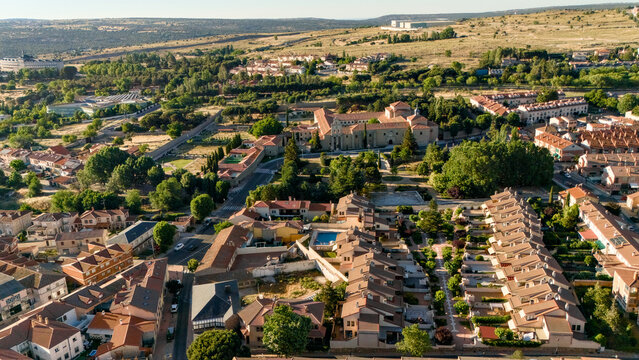 Aerial drone shot of Avila suburbs with residential blocks gardens and mountains in background