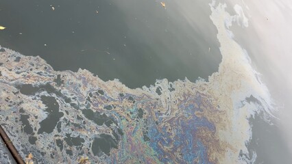 Naklejka premium Iridescent oil slick polluting dark water surface