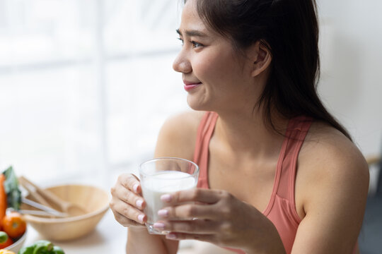 Young Asian woman drinking milk for healthy lifestyle and diet.