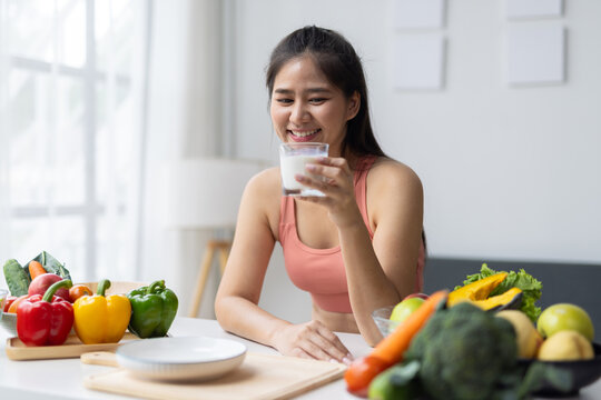 Young Asian woman drinking milk for healthy lifestyle and diet.