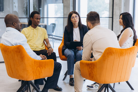 Diverse people meeting in a support group, counselor facilitating discussion and listening to different viewpoints