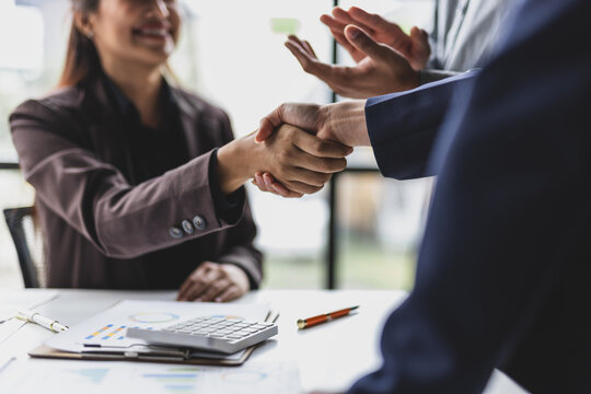 Business partners making a deal, shaking hands in office, partnership, cooperation, and success. People applauding meeting.