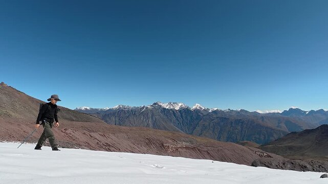 4K mountaineer crossing a snowy ridge with breathtaking alpine mountain scenery.