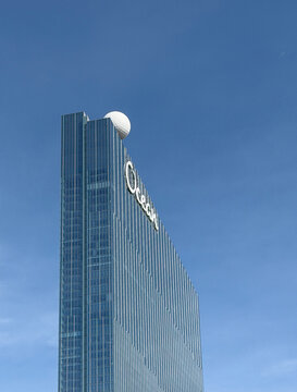 A sleek glass Ocean Casino and Hotel Resort in Atlantic City, New Jersey rises into a clear blue sky, featuring bold signage and a distinctive white sphere on the roof conveying luxury and urban scale