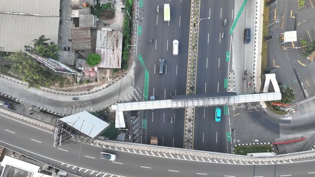 Aerial view of a highway with a pedestrian bridge crossing over traffic in Bekasi Barat, West Java, Indonesia.