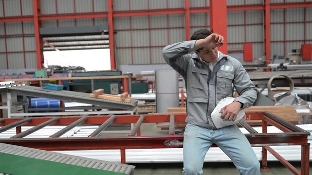 Industrial worker wiping sweat after physical work