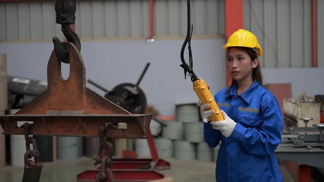 Female worker using overhead crane control pendant