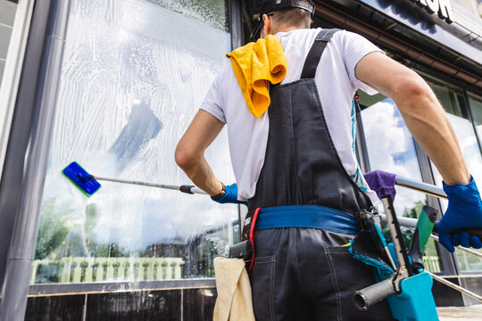 Professional Window Cleaner Washing Commercial Building Glass with Squeegee