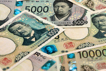 Japanese yen money banknotes pile on table. Japan bills of JPY currency. Concept of economy © Larysa