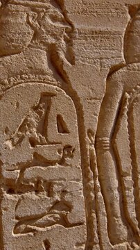 Karnak Temple in Luxor, Egypt. Close-up ancient Egyptian wall relief with pharaoh and gods figures, cartouche and hieroglyphics at Karnak Temple Luxor. Authentic history and documentary.