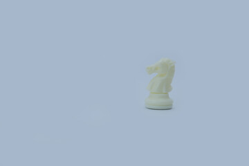 White Plastic Chess Knight on Gray Background with Copy Space © Юрий Несмашный