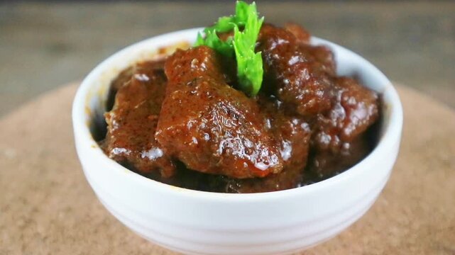 Traditional Indonesian Beef Rendang in White Bowl, rotating display. Turning
